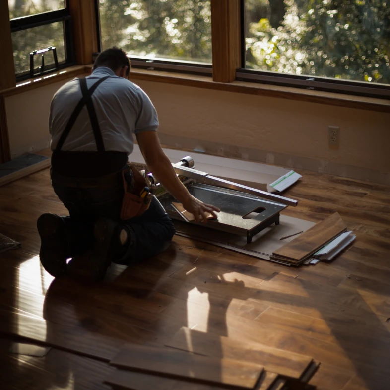 Worker installing wooden floor panels